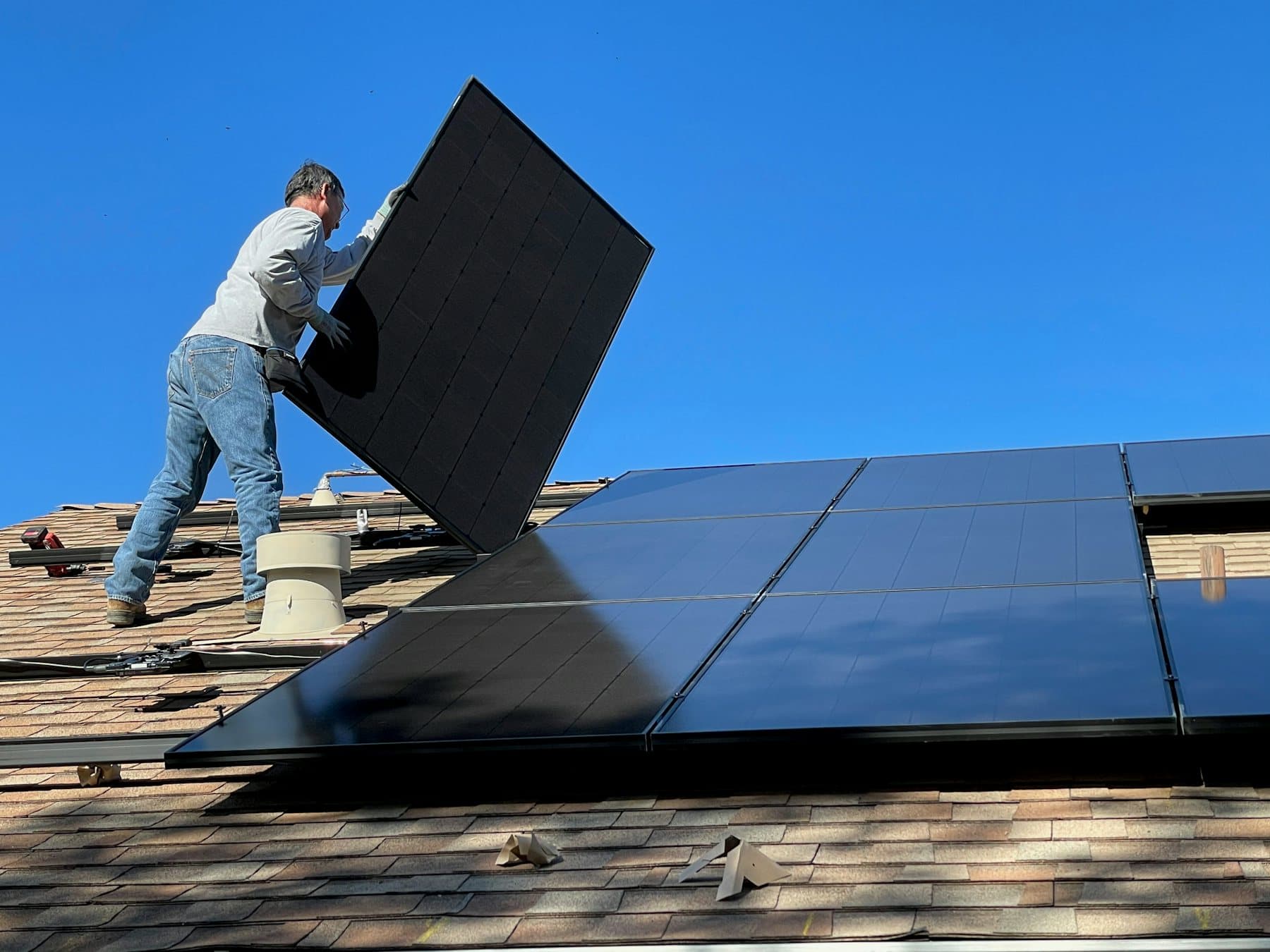 Technicien posant un panneau photovoltaïque sur une toiture